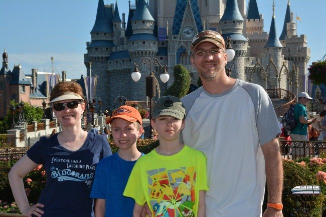 Why you should use Disney's PhotoPass service. Family in front of Cinderella Castle.